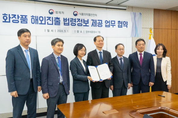 이완규 법제처장(좌 4번째)과 오유경 식약처장(좌 3번째)이 업무협약서를 들어보이고 있다.