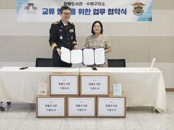 박미영 창룡도서관 관장(오른쪽)과 김현우 수원구치소 소장(왼쪽)이 업무협약을 체결하고 함께하고 있다.