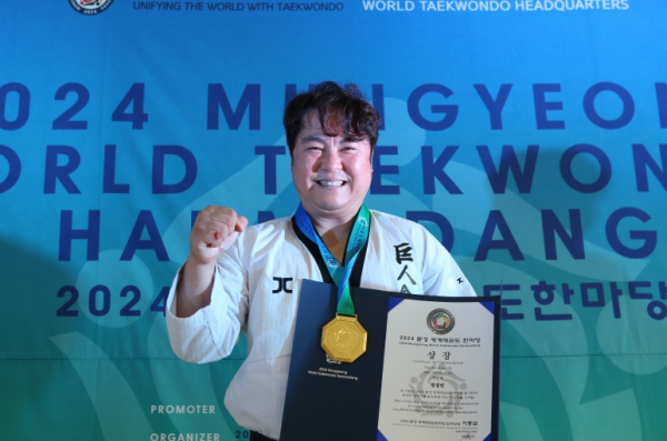 주먹격파 시니어 Ⅲ 우승자인 정상민 사범이 메달과 상장을 받은 뒤 주먹을 불끈쥐며 기념사진 촬영을 했다.