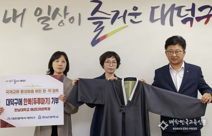 (사진 왼쪽부터) 이은영 한남대학교 패션디자인학과 학과장과 김정아 한남대학교 패션디자인학과 교수, 최충규 대덕구청장이 기부받은 두루마기를 들고 기념 촬영을 하고 있다.